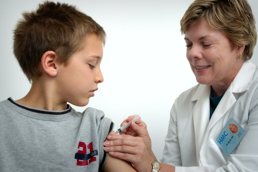 doctor administering vaccine to kid
